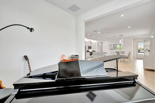 miscellaneous room featuring ceiling fan and light hardwood / wood-style flooring