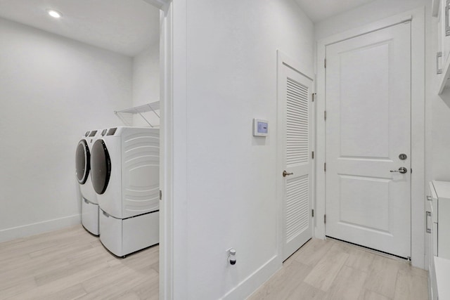 laundry area featuring washer and dryer and light hardwood / wood-style floors