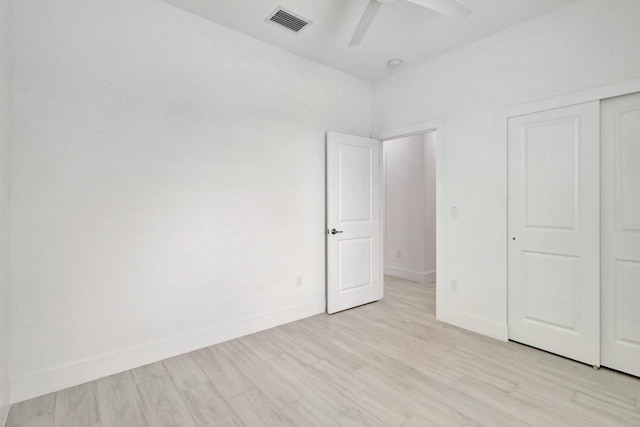 unfurnished bedroom featuring a closet, light hardwood / wood-style flooring, and ceiling fan