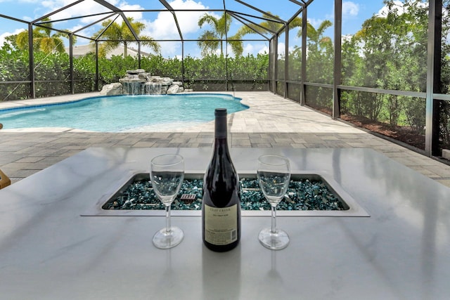 view of pool featuring a patio, pool water feature, and glass enclosure