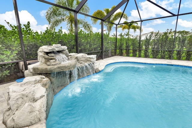 view of swimming pool featuring pool water feature and glass enclosure