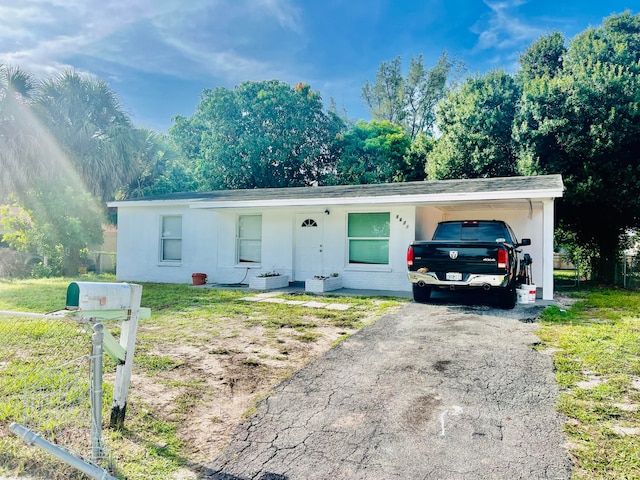 single story home with a front lawn and a carport