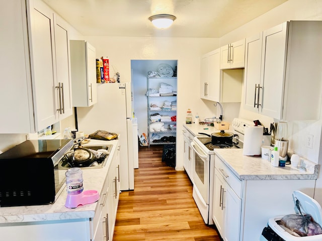 kitchen featuring white cabinets, white range with electric stovetop, and light hardwood / wood-style flooring