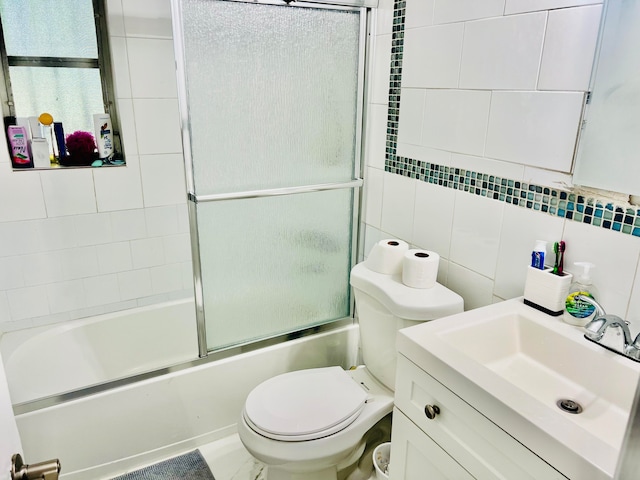 full bathroom featuring vanity, toilet, tile walls, and combined bath / shower with glass door