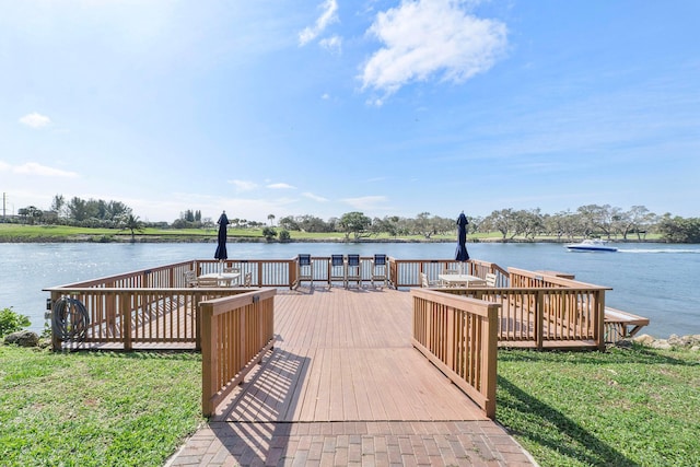 dock area featuring a yard and a deck with water view