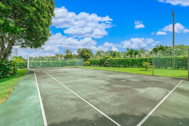 view of tennis court featuring a lawn