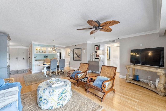 living room with a textured ceiling, crown molding, ceiling fan with notable chandelier, and light hardwood / wood-style floors