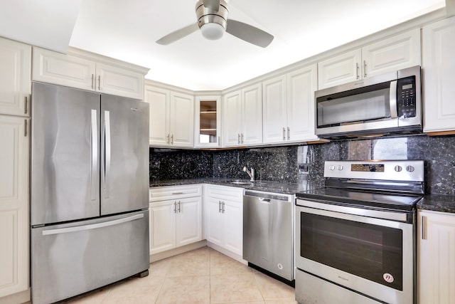 kitchen featuring light tile patterned floors, backsplash, stainless steel appliances, and white cabinetry