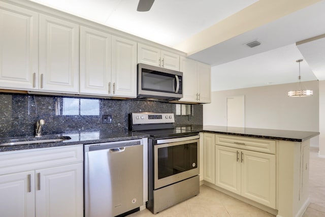 kitchen with sink, tasteful backsplash, light tile patterned floors, appliances with stainless steel finishes, and kitchen peninsula