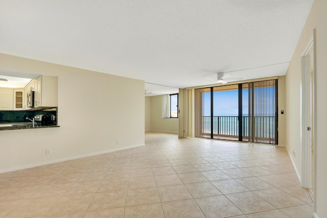 spare room featuring light tile patterned flooring and ceiling fan