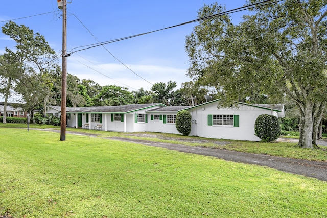 4050 Greenwood Dr, Fort Pierce, FL 34982 - ranch-style house with stucco siding, aphalt driveway, and a front yard