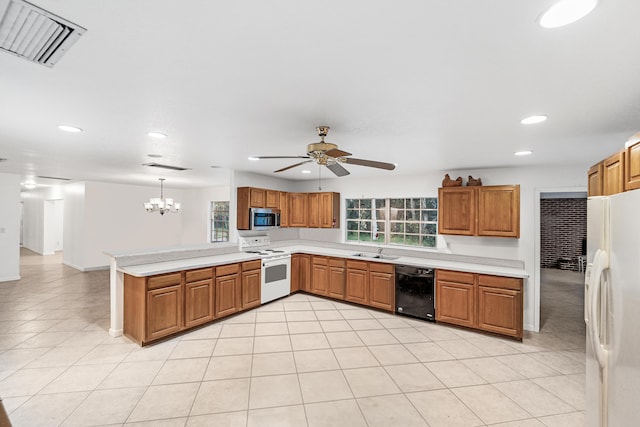 4050 Greenwood Dr, Fort Pierce, FL 34982 - kitchen featuring visible vents, a peninsula, white appliances, a sink, and brown cabinetry
