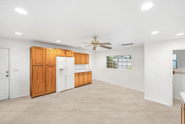 4050 Greenwood Dr, Fort Pierce, FL 34982 - kitchen with light countertops, recessed lighting, a ceiling fan, white refrigerator with ice dispenser, and brown cabinetry