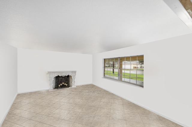 4050 Greenwood Dr, Fort Pierce, FL 34982 - unfurnished living room with tile patterned flooring, a fireplace with raised hearth, and baseboards