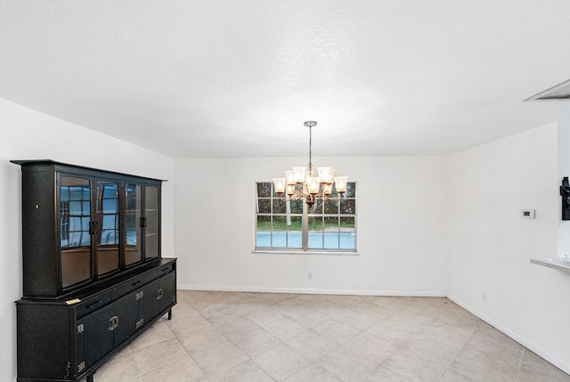 4050 Greenwood Dr, Fort Pierce, FL 34982 - empty room with baseboards, a textured ceiling, and an inviting chandelier