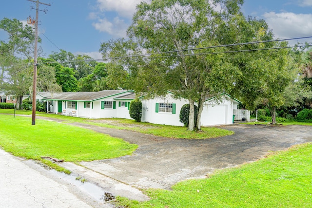 4050 Greenwood Dr, Fort Pierce, FL 34982 - view of front facade featuring stucco siding, a garage, aphalt driveway, and a front lawn