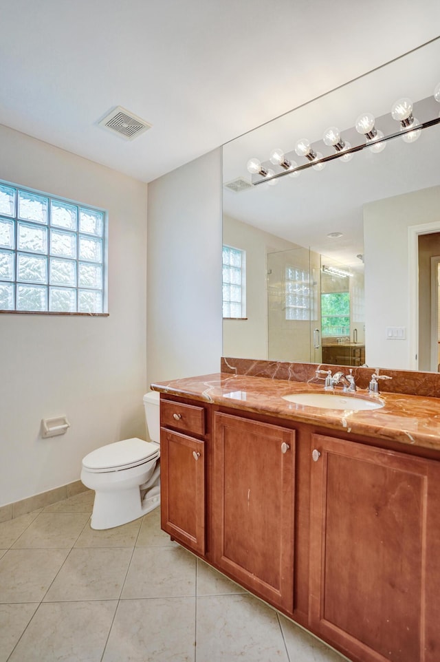 bathroom with tile patterned flooring, an enclosed shower, vanity, and toilet