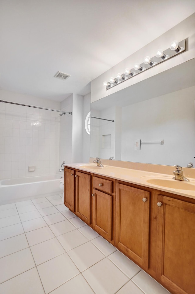 full bathroom featuring toilet, vanity, tile patterned floors, and tiled shower / bath combo