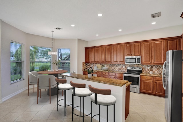 kitchen with pendant lighting, stainless steel appliances, tasteful backsplash, a breakfast bar area, and stone counters