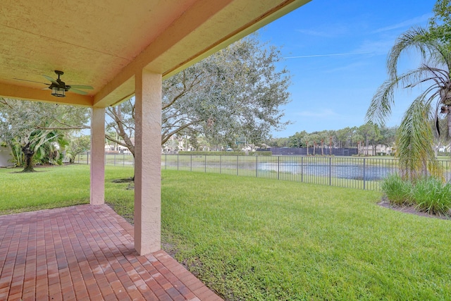 view of yard with a patio area, ceiling fan, and a water view