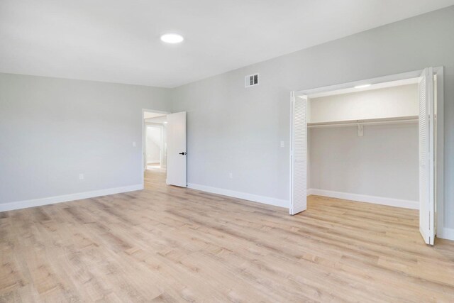 unfurnished bedroom with a closet and light wood-type flooring