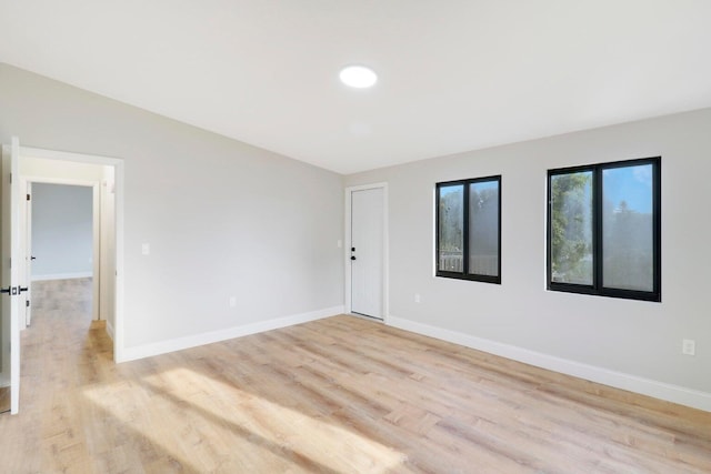 spare room featuring light wood-type flooring and lofted ceiling