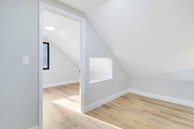 additional living space featuring light wood-type flooring and lofted ceiling