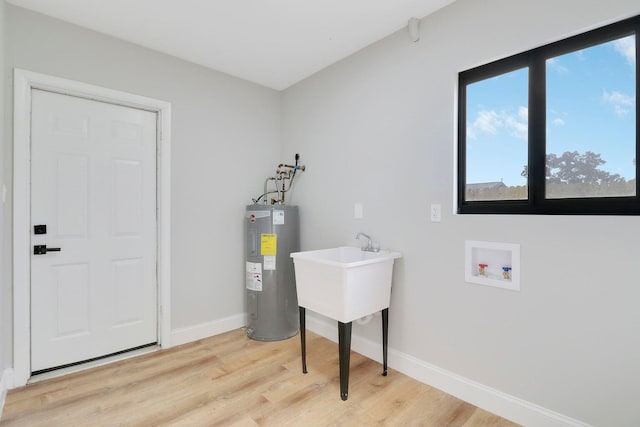 laundry area with hookup for a washing machine, water heater, and light hardwood / wood-style floors