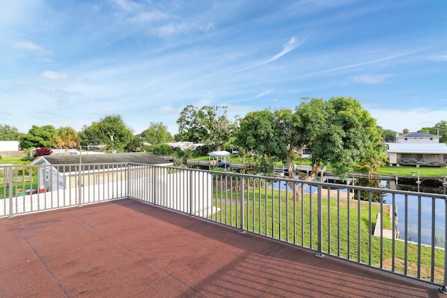 deck with a water view and a lawn