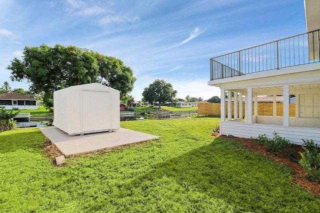 view of yard with a storage shed and a balcony