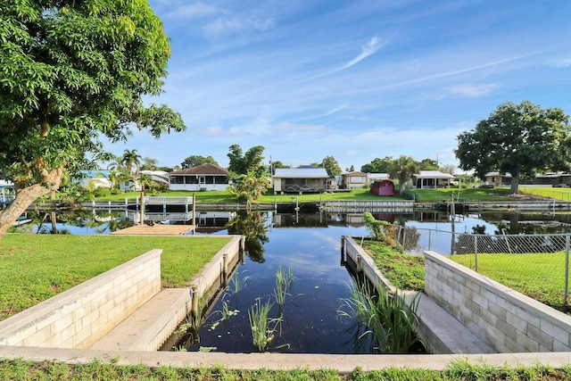 view of dock with a water view and a yard