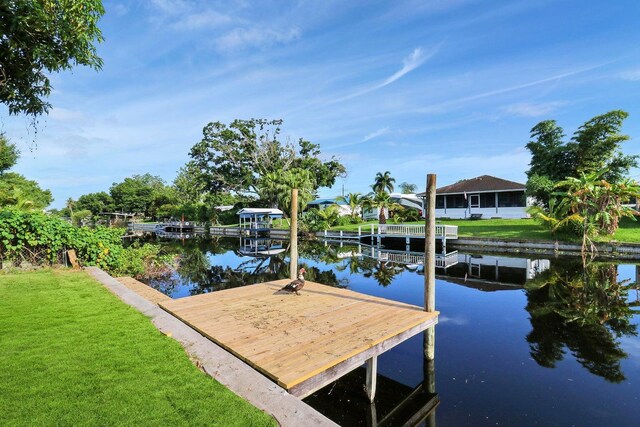 dock area with a water view and a yard