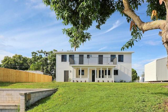 view of front of house featuring a balcony and a front yard