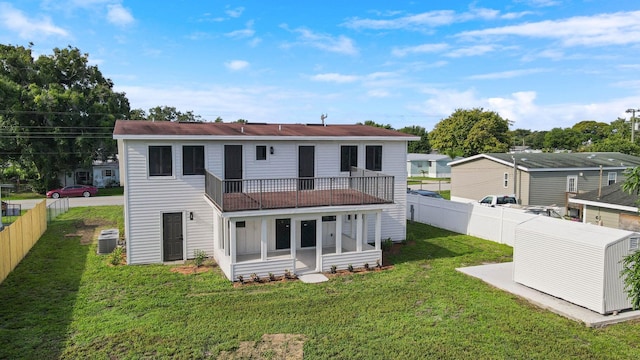 back of house with a yard and central AC