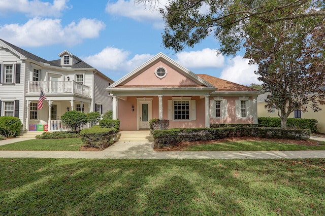 view of front of home featuring a balcony, a porch, and a front yard