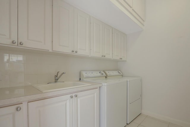 clothes washing area with separate washer and dryer, sink, light tile patterned floors, and cabinets