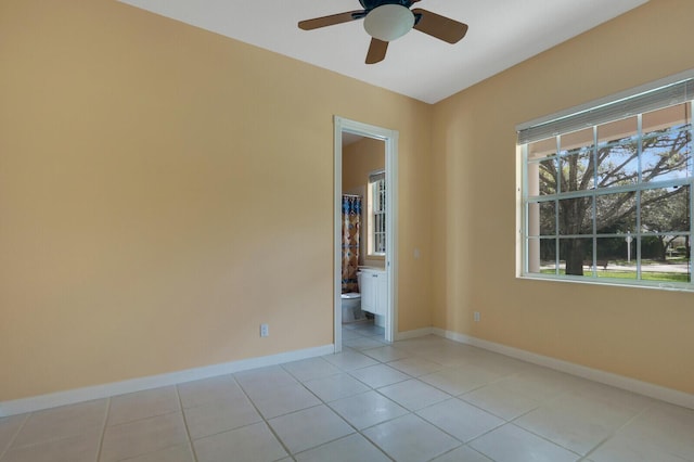 tiled spare room featuring ceiling fan