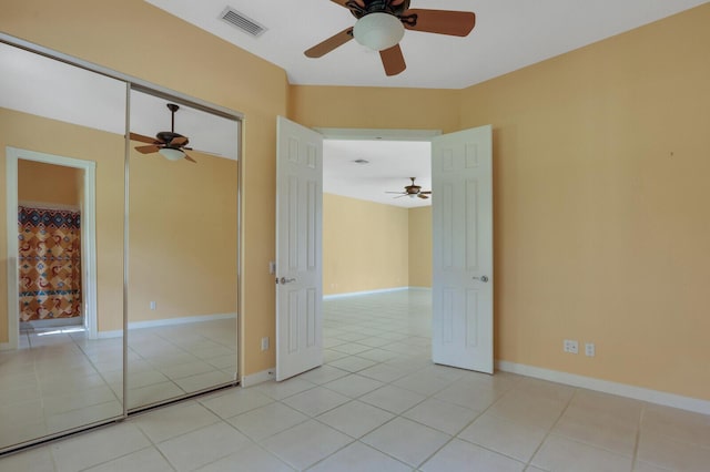 empty room featuring ceiling fan and light tile patterned floors