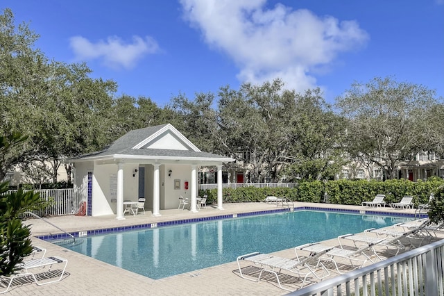 view of pool featuring an outbuilding and a patio