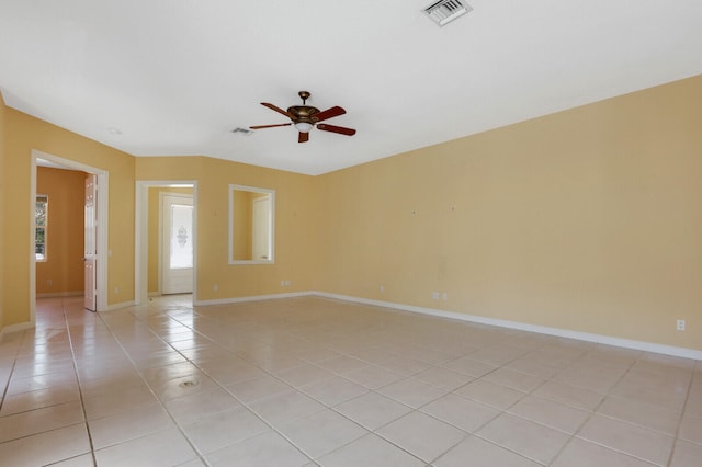 unfurnished room with ceiling fan, a healthy amount of sunlight, and light tile patterned flooring