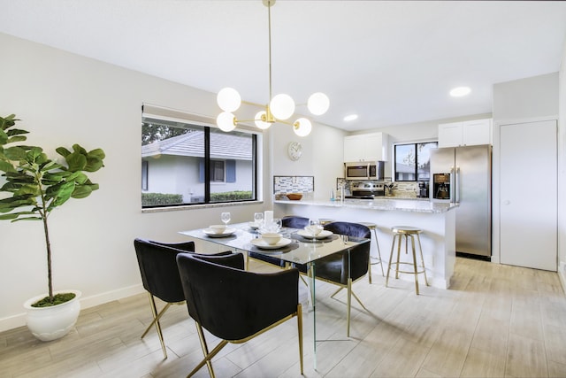 dining space featuring recessed lighting, baseboards, and light wood finished floors