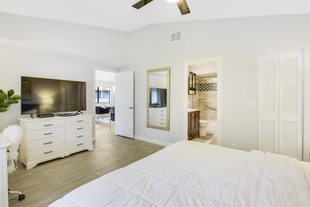 bedroom with visible vents, lofted ceiling, ceiling fan, light wood-style floors, and ensuite bathroom