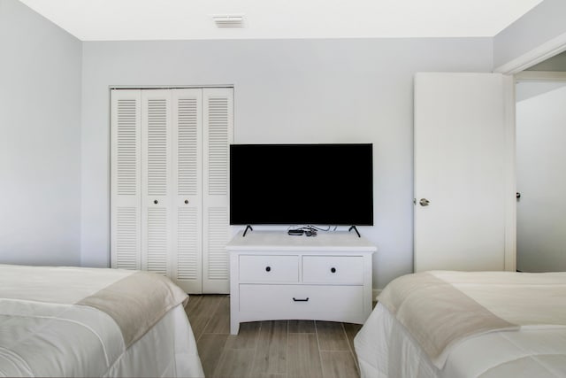 bedroom with light hardwood / wood-style floors and a closet