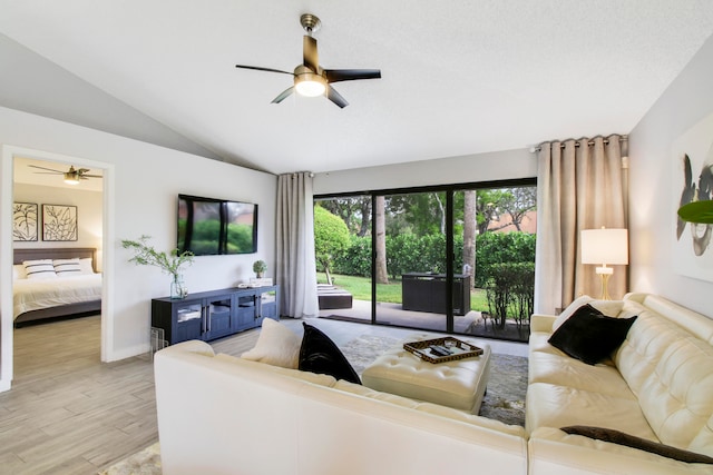 living room with vaulted ceiling, a healthy amount of sunlight, ceiling fan, and light hardwood / wood-style floors