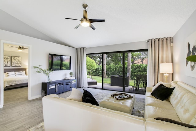 living room with ceiling fan, baseboards, light wood-type flooring, and lofted ceiling