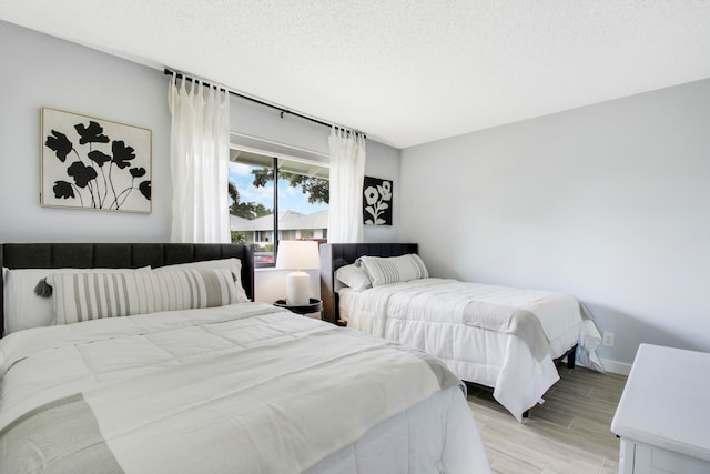 bedroom with light hardwood / wood-style floors and a textured ceiling