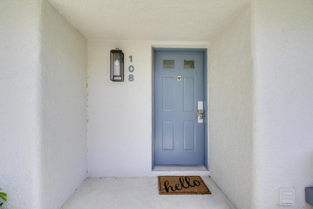 view of exterior entry featuring stucco siding