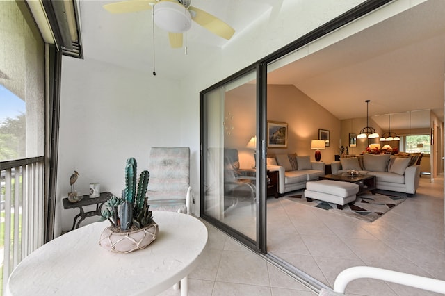 interior space featuring ceiling fan with notable chandelier and lofted ceiling