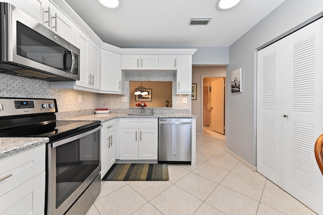 kitchen with decorative backsplash, sink, white cabinets, and stainless steel appliances