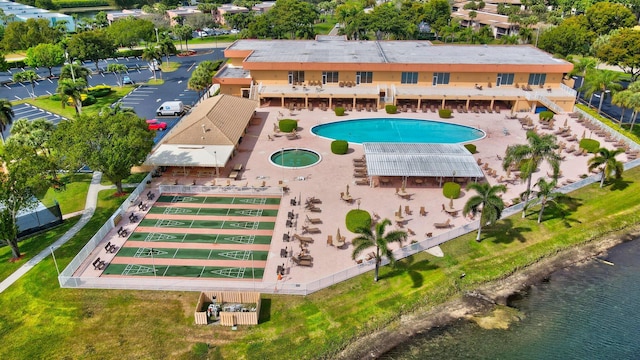 view of swimming pool featuring a water view and a patio